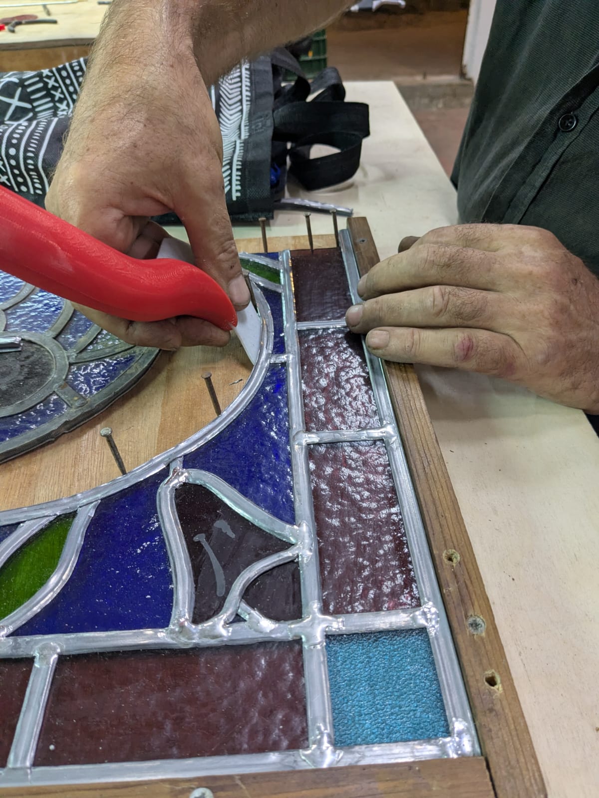 Stained glass artist testing the prototype on a leaded panel